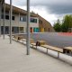 Eksteriørfoto Kongsgårdmoen skole. Skolebygget omfavner en indre skolegård med asfalt og sittebenker. Det er også områder med gummibelegg og lekestativer.