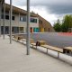 Eksteriørfoto Kongsgårdmoen skole. Skolebygget omfavner en indre skolegård med asfalt og sittebenker. Det er også områder med gummibelegg og lekestativer.