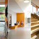 Tre interiørfoto av Åskollen skole. Fra trapp og amfi i blbioteket, samt fra en korridor med fargerik benk og toalettvegg.